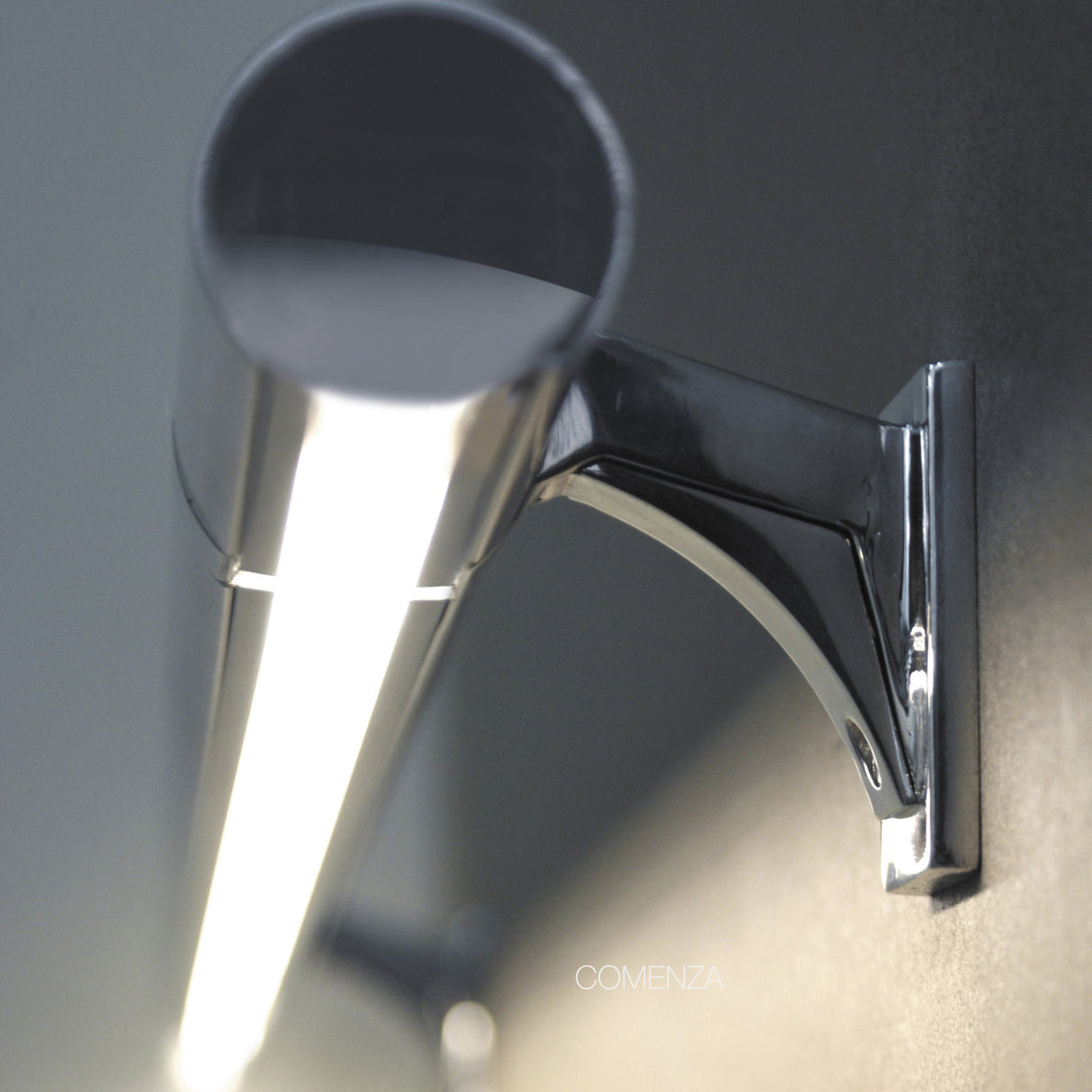 Close-up of the Round Stainless Steel LED Handrail Profile ~ Model Comenza, mounted on a wall bracket. Features integrated LED lighting and a sleek, modern design with the COMENZA name subtly visible.
