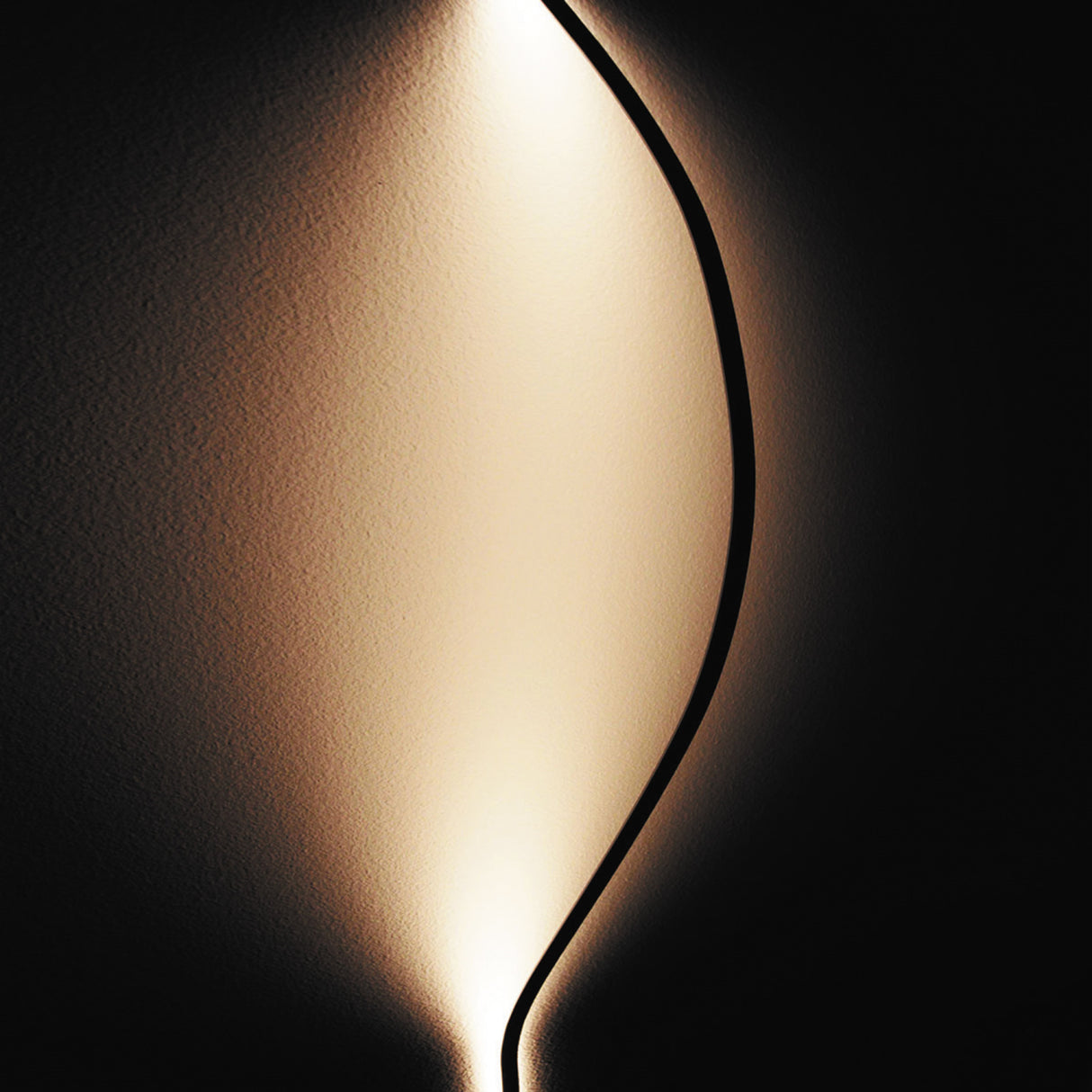 A curved, black line resembling the Ultra Thin Bendable LED Strip Channel ~ Model Milano Slim runs vertically through a softly lit, abstract background, creating a symmetrical glow that highlights its ultra-slim profile and smooth curve.