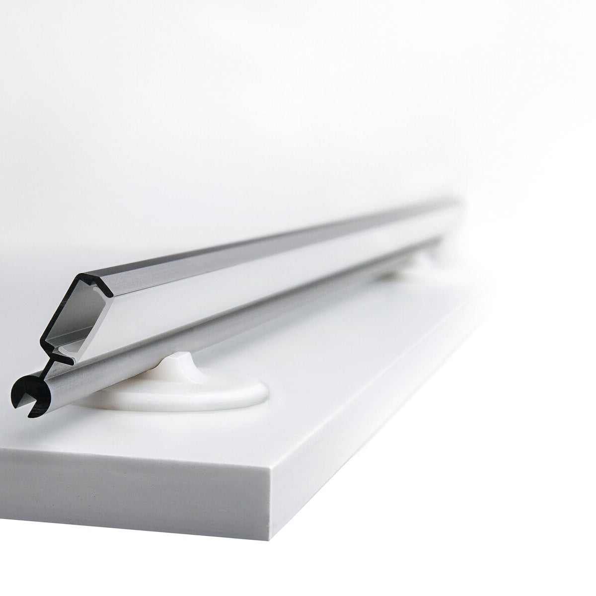A close-up of the Mounting Bracket for Poli Profile shows its metallic, angular rod mounted horizontally on two white, circular supports attached to a flat white surface against an uncluttered background.