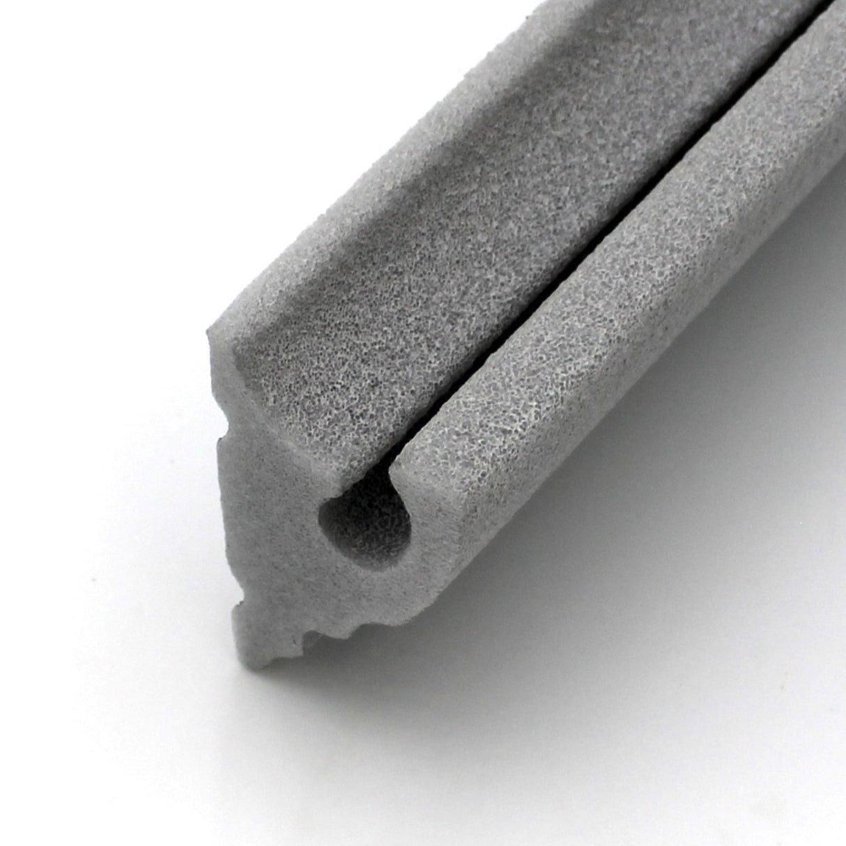 A close-up of the LED Foam CoveLight Molding ~ Model Cornice CoveLight in gray, featuring a grooved and hollow profile similar to foam cornice molding, ideal for sealing gaps and enhancing door or window areas.