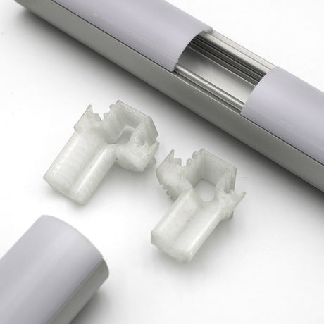 Close-up of two translucent plastic mounting clips, a T Joiner for Alu-Round Profile, and white/metallic Alu-Round profile rail parts on a white background.