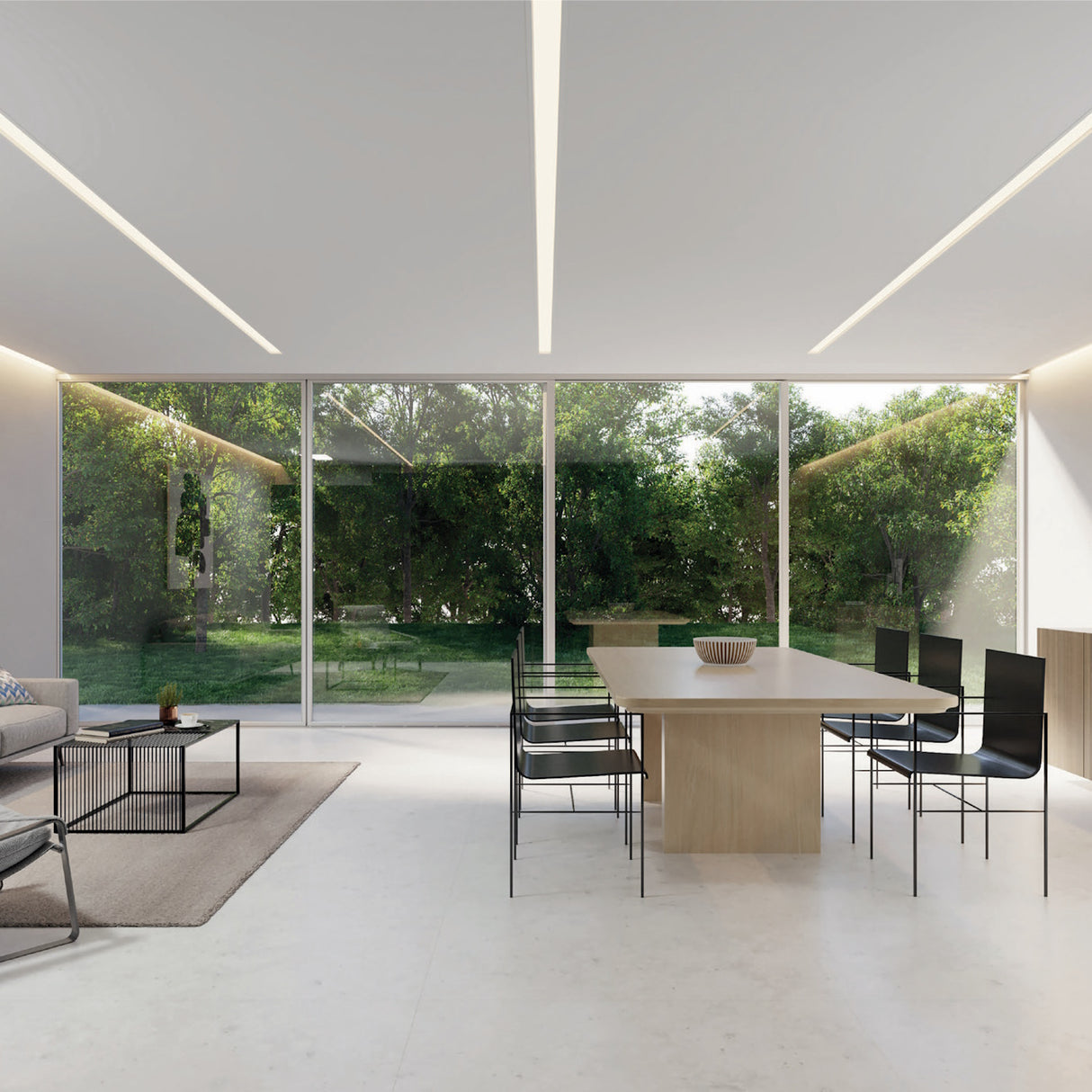 Modern dining and living area with minimalist furniture, large glass walls overlooking a lush garden, ample natural light, and sleek Shallow Ceiling Recessed LED lighting Chanel ~ Model Amara brightening the clean, open space.