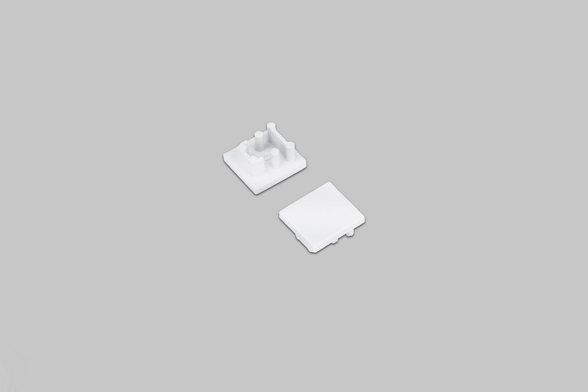 Two small white square End Cap for Bend8 Profile pieces, one shown from the top and one shown from the underside with mounting pegs.