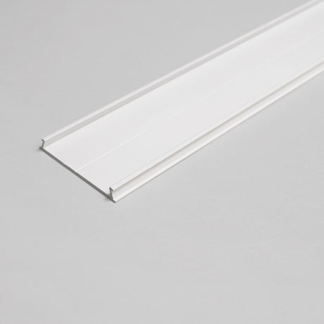 The Complementary Cover Profile ~ Model C10, a white, flat, rectangular trim strip with slightly raised edges ideal for LED profiles, is shown on a light gray surface in an angled overhead photo.