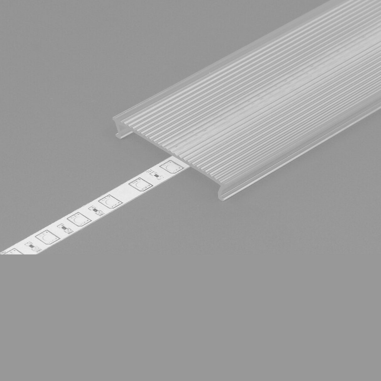 The LED Channel Cover ~ C10 Click, a clear ribbed opal PMMA cover, partially shields a white LED strip with visible chips, shown against a plain gray background.