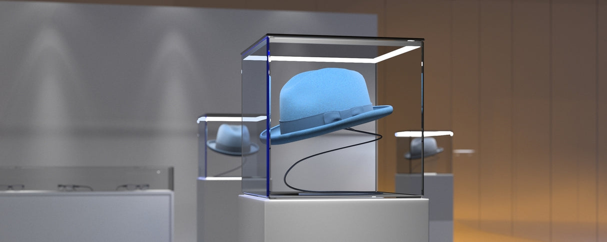 A light blue bowler hat is displayed in a glass case on a pedestal in a modern, softly-lit space, with the Corner LED Channel ~ Model Cabi12 Duo emphasizing the hats reflection in the background.