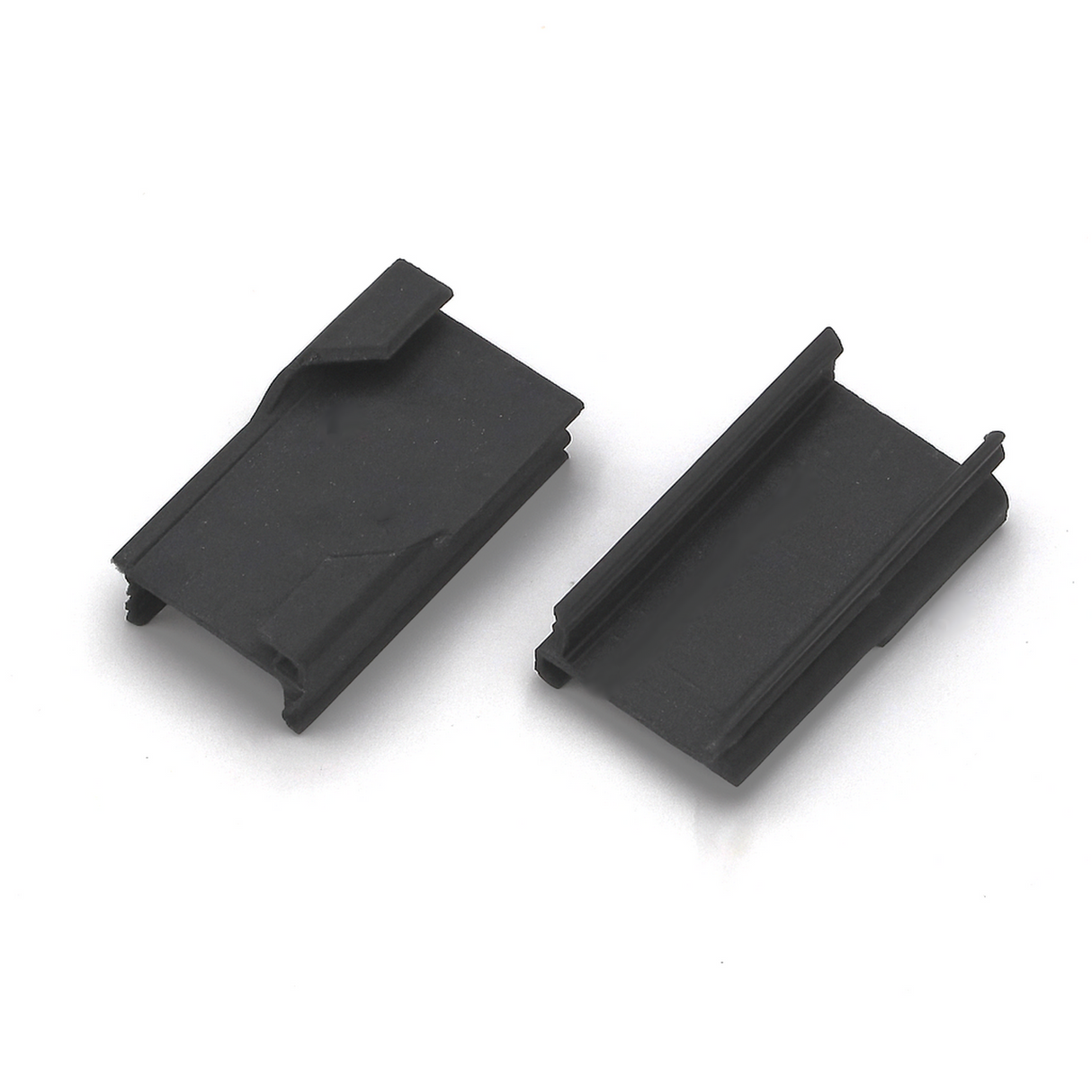 Two black Roma XL Drop Ceiling Clips, rectangular with grooves and angular edges, are shown on a white background—one facing up to display the top surface, and the other facing down to reveal its grooved underside for mounting.