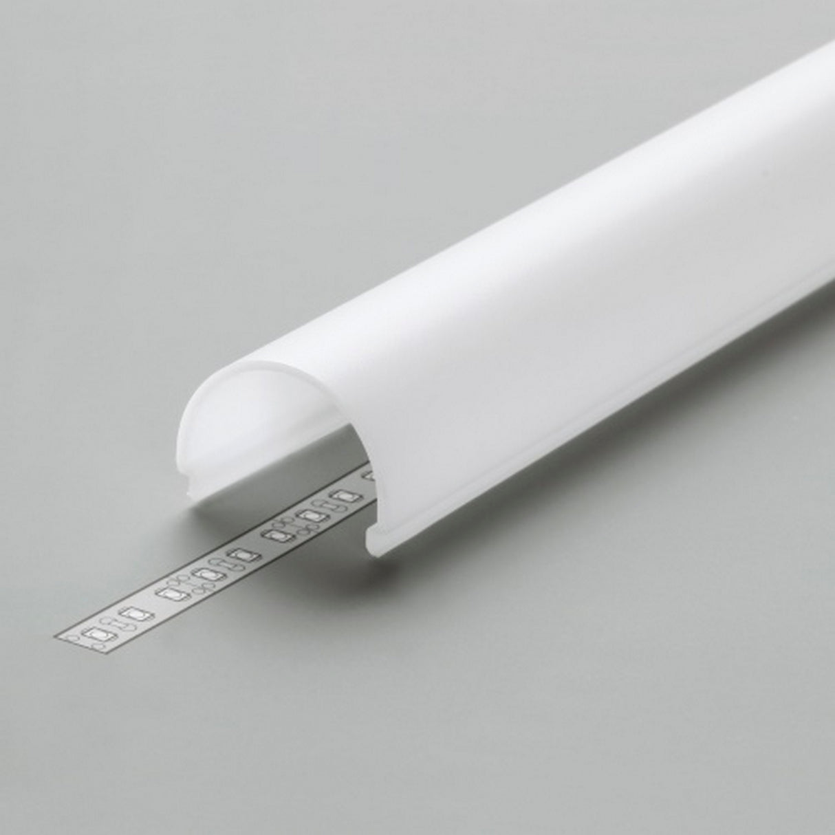 The LED Channel Cover ~ D9 Click, a white semi-circular cover made of durable PMMA, rests on a gray surface and partially conceals a silver LED strip with small visible bulbs.