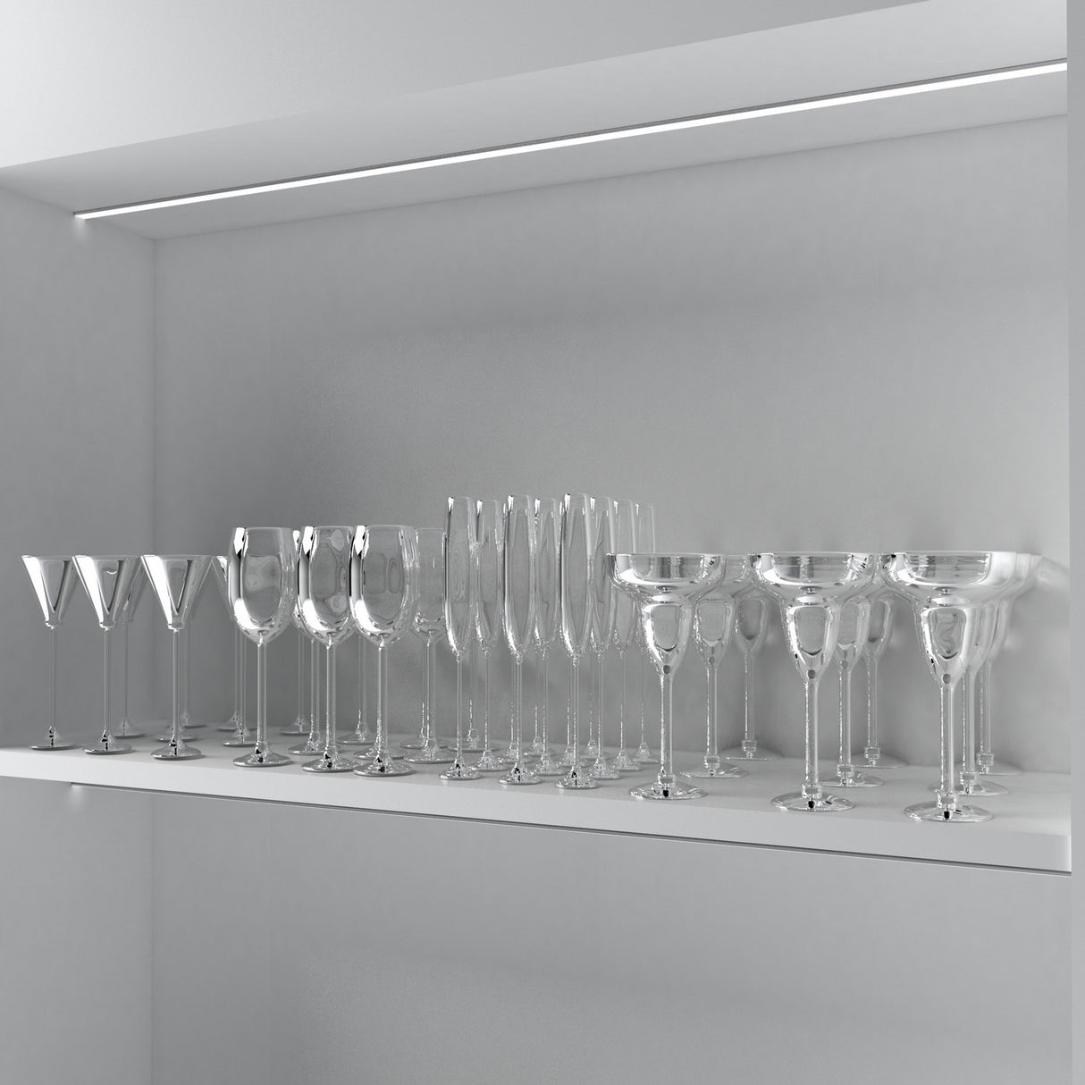 A row of clear, empty wine and cocktail glasses sits neatly on a white shelf in a sleek cabinet illuminated by the 0.53 Small Recessed LED Channel ~ Model Frankfurt, enhancing its minimalistic look with bright, recessed lighting.