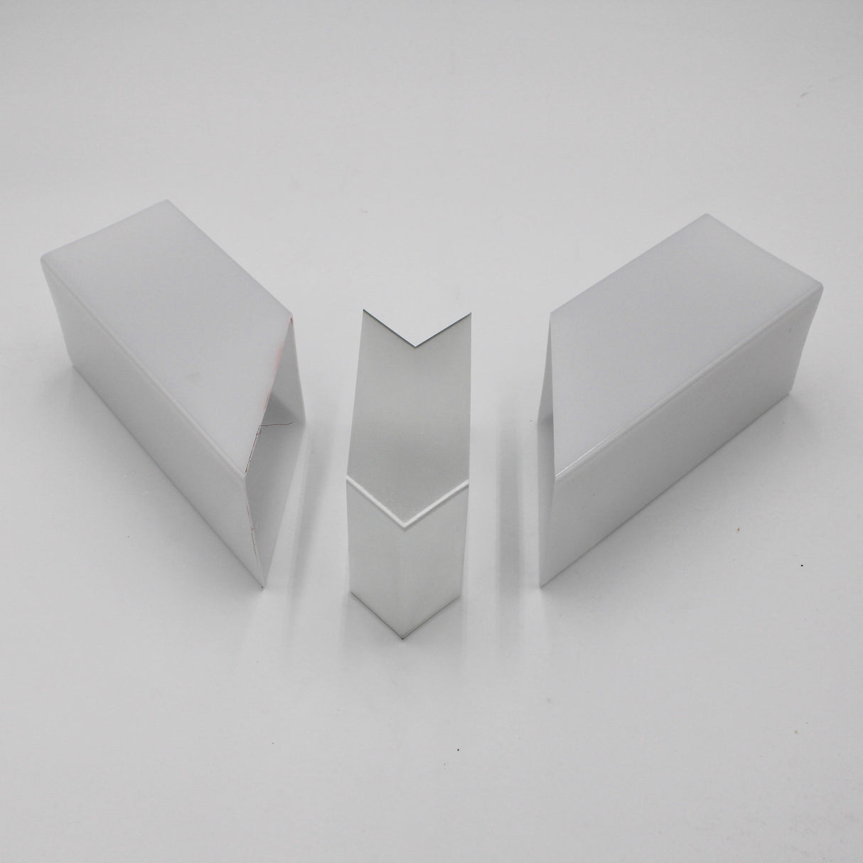 Three Translucent Elbows for Holston74 Profile are arranged on a white surface—the middle one upright, while the outer two lie on their sides, facing inward.