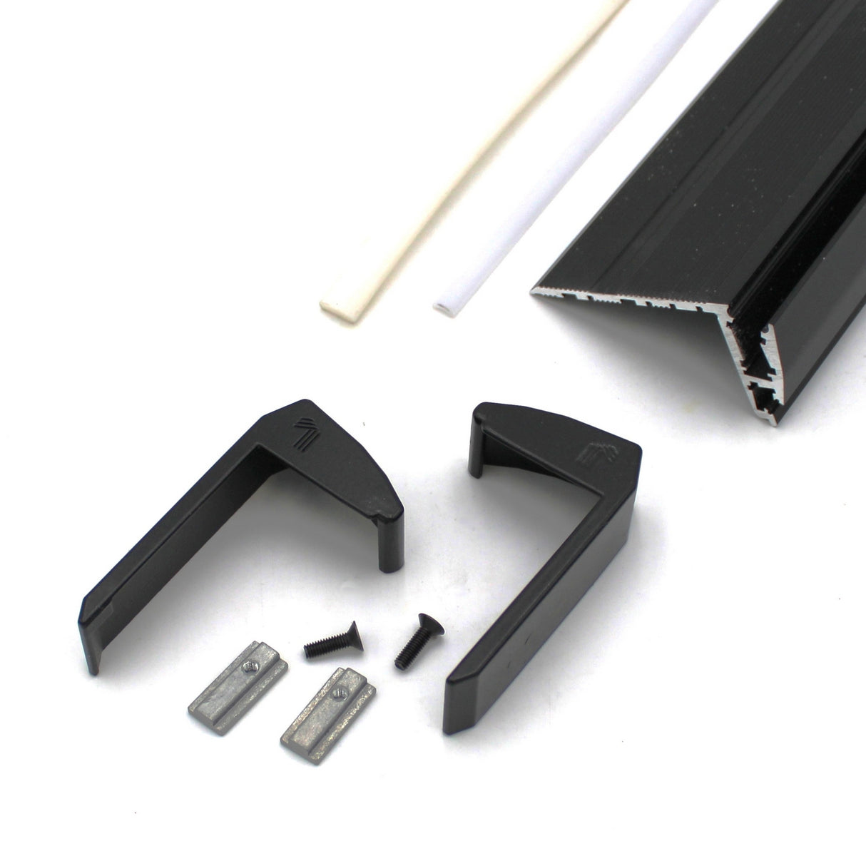 A pair of black End Caps for Niza Duo, with a metal frame piece, two small metal clips, two screws, and two thin white plastic strips displayed on a white surface.