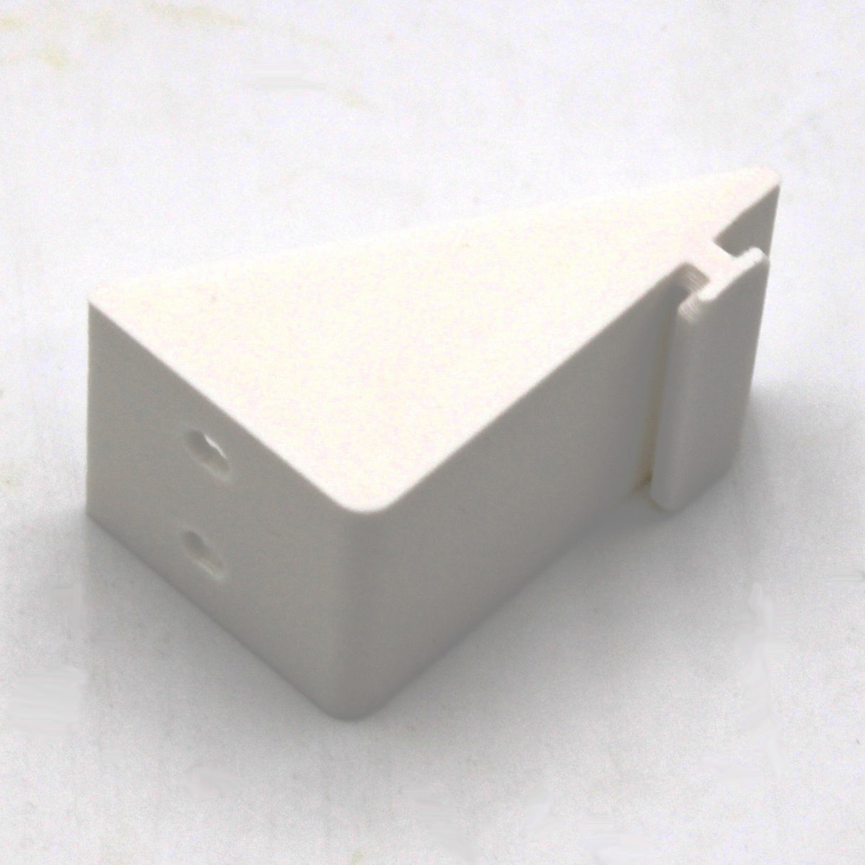 A white, wedge-shaped Plastic Mounting Bracket for Caracas Profile with two holes on one end and a notched section on the other, perfect for securing LED profiles, shown on a plain surface.