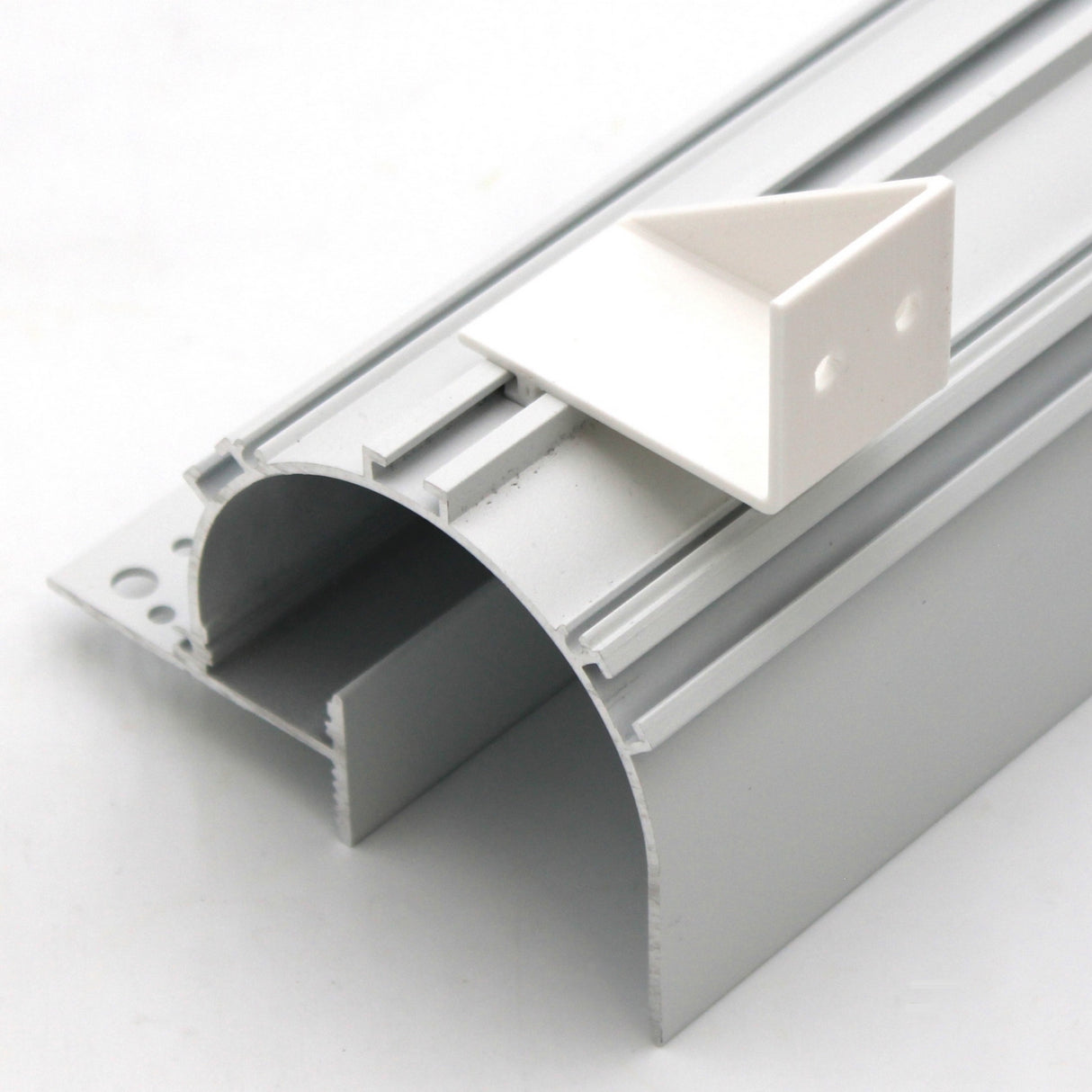 A silver aluminum Caracas LED profile with a curved surface is shown, topped with a small white Plastic Mounting Bracket for Caracas Profile.