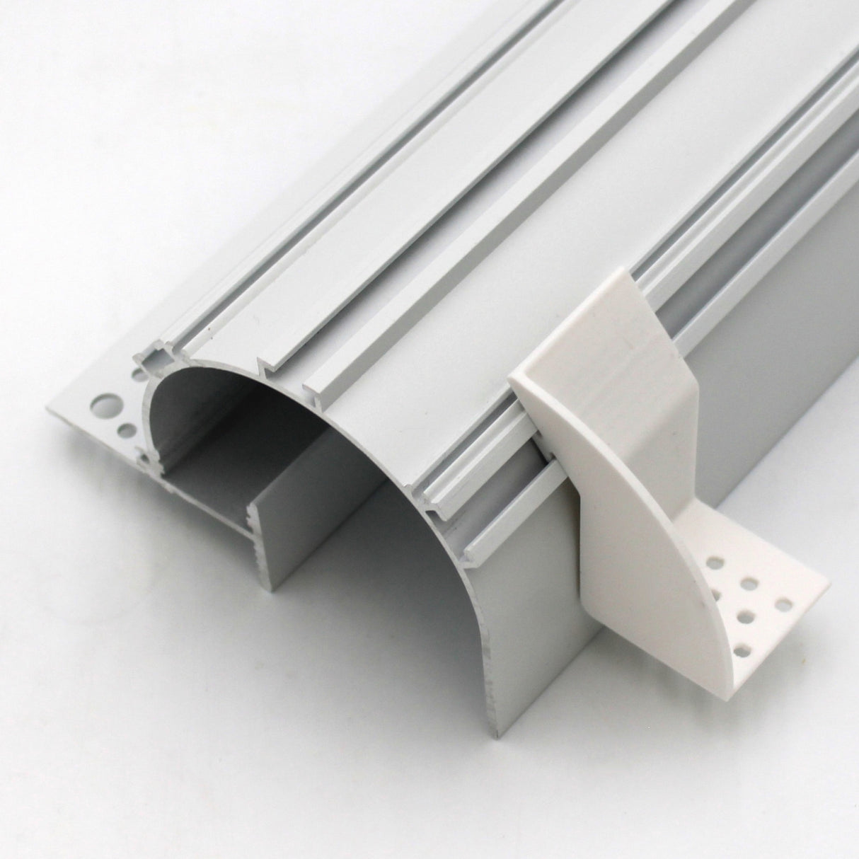 A plastic mounting bracket designed for the Caracas profile, shown in close-up with its detachable white end cap featuring two rows of base holes and curved grooves on a silver aluminum LED profile.