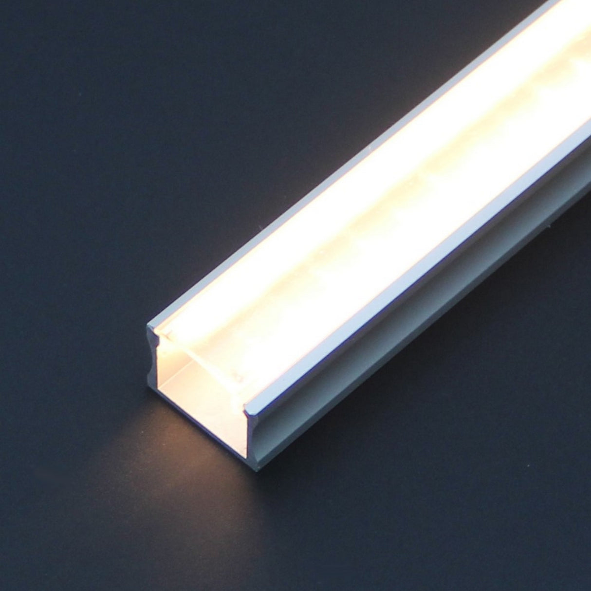 A close-up of a rectangular Diffuser for SLW8, RSLW8, SLW15, RO38, Wall LED Lamp series profiles with a frosted finish, glowing warmly on a dark surface.