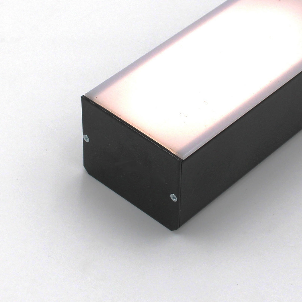 A 2 wide black aluminum linear LED lighting profile (Model PL55-FL) with a slightly pinkish reflective top is shown on a white background, secured with screws on the end facing the camera.
