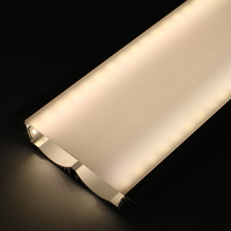 A close-up of the 4.5 Large Recessed LED Channel (Model RPLW116) glowing warmly in a dark space, its frosted cover diffusing soft, even light and providing extra-wide output for enhanced illumination.