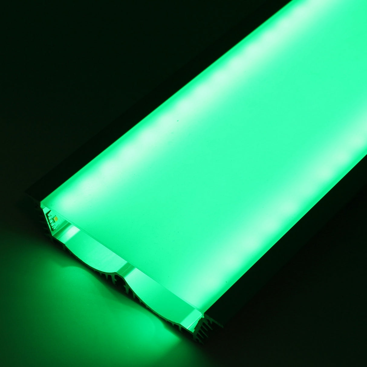 A close-up of the 4.5 Large Recessed LED Channel (Model RPLW116) glows with bright green light against a dark background, its rectangular edges and surface clearly illuminated to showcase the extra-wide light output.