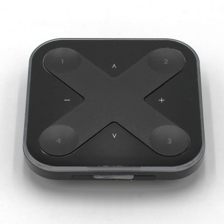 The Casambi basicDIM Bluetooth LED Wall Remote Control (Model Xpress-LR) is a black, square remote with rounded corners and four numbered buttons at each corner, plus arrow and +/- symbols in an X pattern for wireless lighting control.