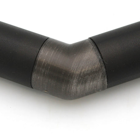 Close-up of a Translucent Elbow for Oslo Profile, showing the 90-degree angled connector joining black metal pipes. The transition between straight sections is clear against a white background.
