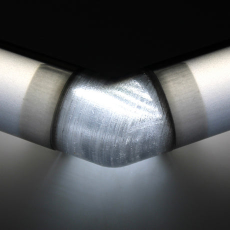 Close-up of a translucent elbow for Oslo Profile with smooth, polished edges and distinct joints, illuminated from below against a dark background.