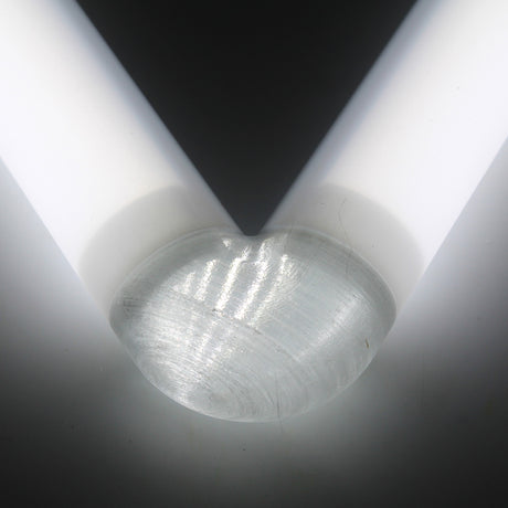 Close-up of the Translucent Elbow for Oslo Profile, where two white diffuser tubes meet at a rounded, transparent corner in a V shape against a dark background, with light reflecting off the PETG surfaces.
