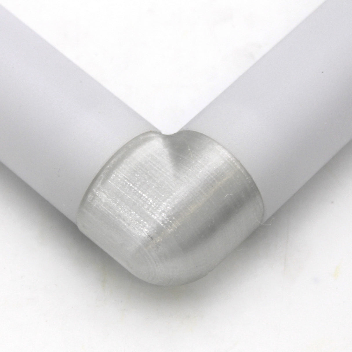Close-up of two white Oslo profiles joined at a right angle with the Translucent Elbow for Oslo Profile, featuring a smooth, rounded connector against a white background.