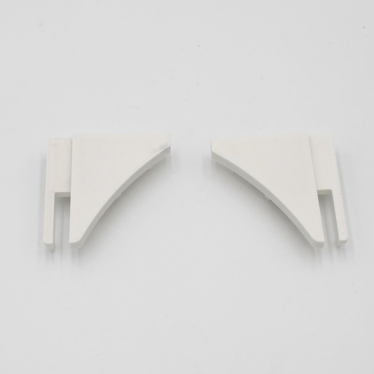 Two small, white, triangular plastic end caps with slotted ends sit side by side on a plain white background—perfect for finishing the End Cap for Pula P10 Profile made from durable PETG.