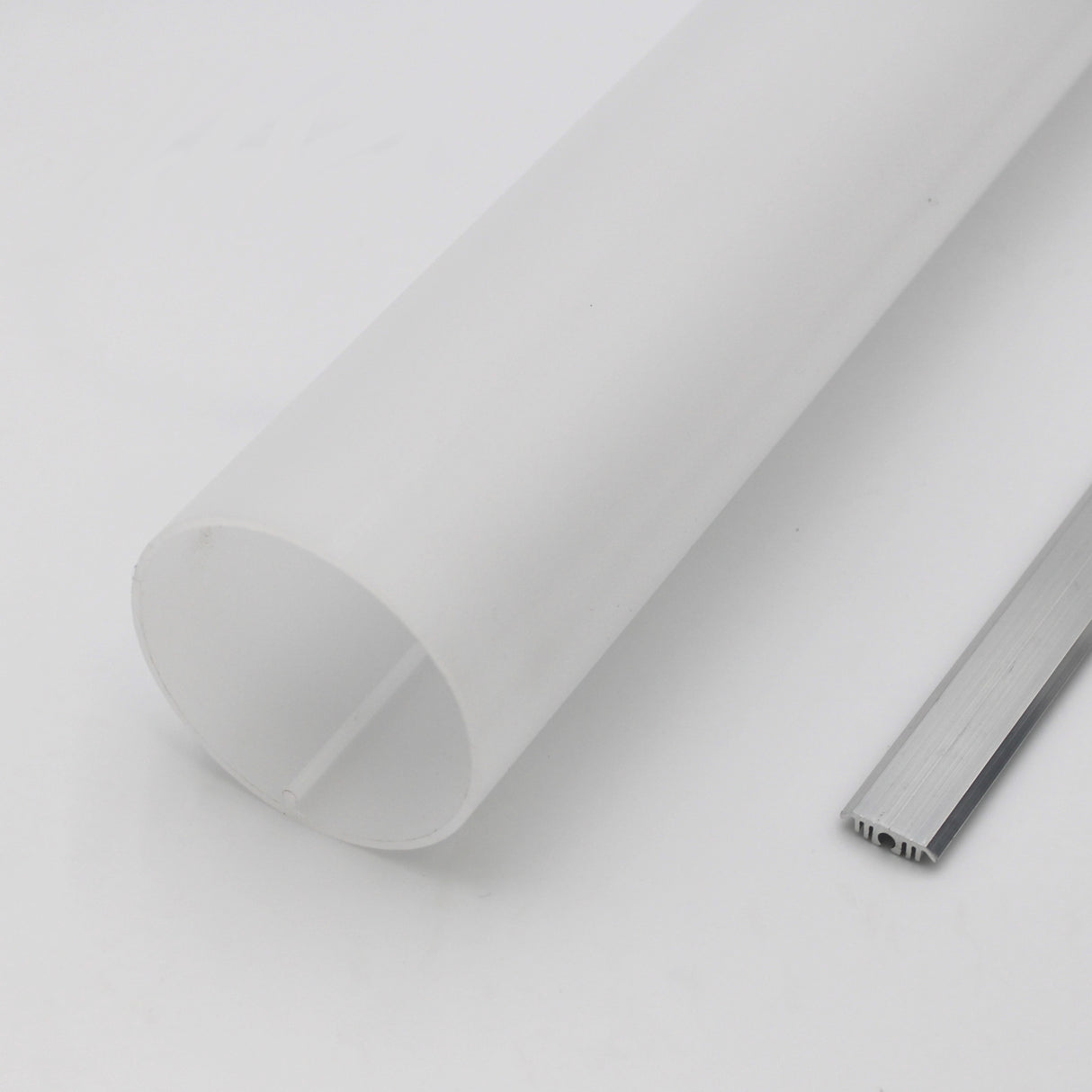 A 2.56 round acrylic LED lighting tube (Model Sierra65) rests beside a slim, rectangular aluminum strip on a plain white surface.