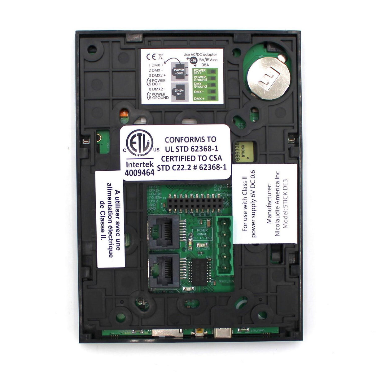 A close-up of the Nicolaudie STICK-DE3, a wall-mounted touch-sensitive DMX lighting controller, shows its circuit board with battery, connectors, certification labels, and technical details on a rectangular black base.