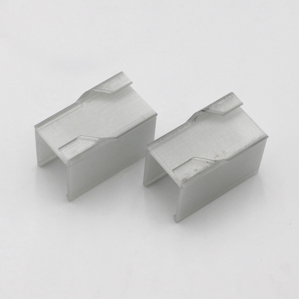 Two rectangular, silver Drop Ceiling T-Bar Linea20 Clips with open sides and angled top notches, designed as accessories for Linea20 profile mounting, are shown on a plain white background.