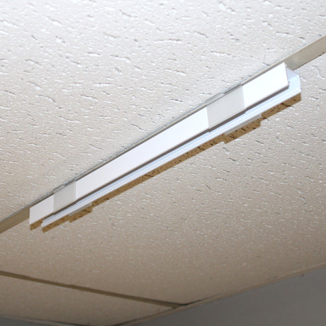 A Drop Ceiling T-Bar Linea20 Clip is installed in a white, textured ceiling with acoustic tiles and a drop-ceiling frame. The light fixture is currently turned off.