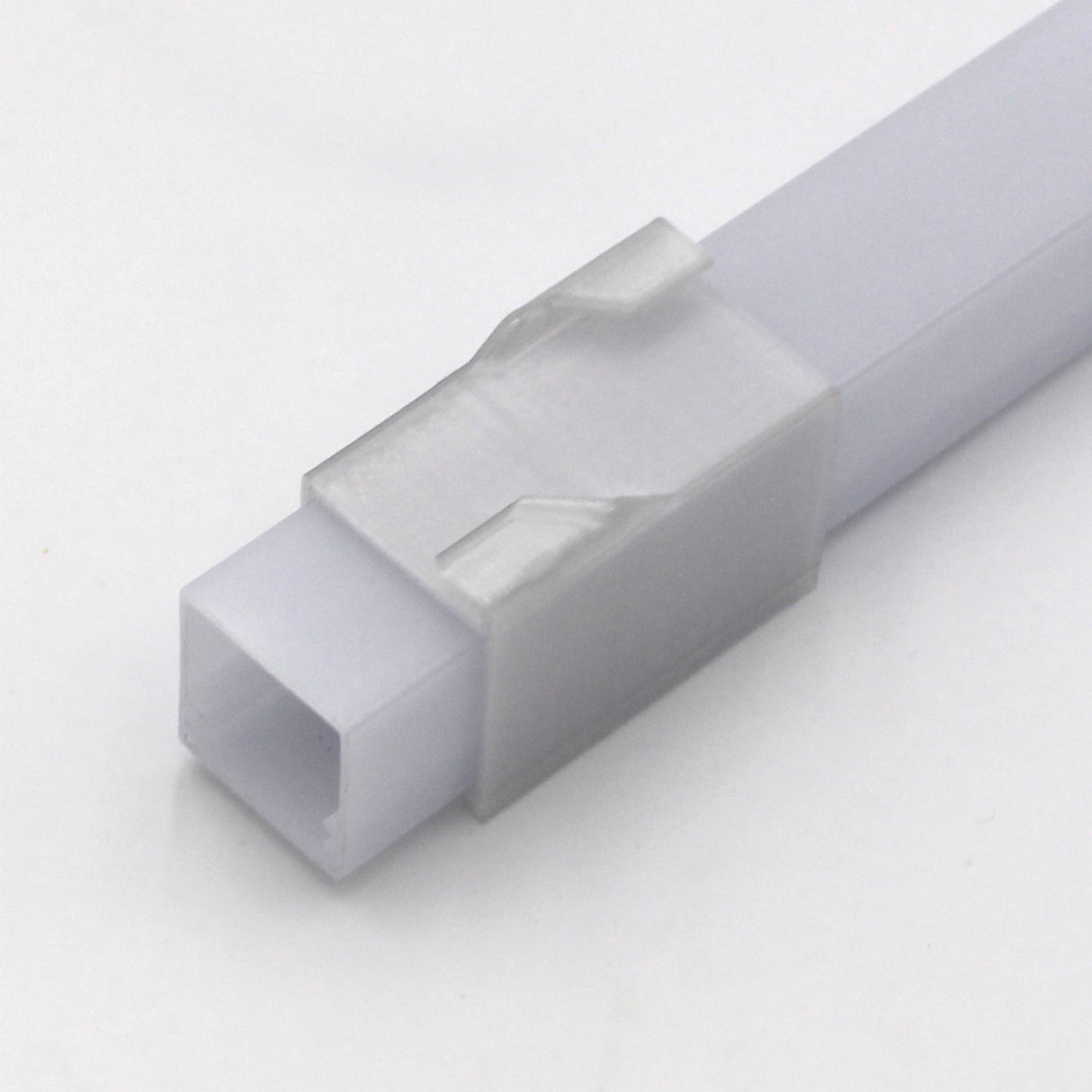 Close-up of a white plastic Visby Drop Ceiling T-Bar Clip with a transparent locking clip, compatible with Visby profile systems, on a plain white background.