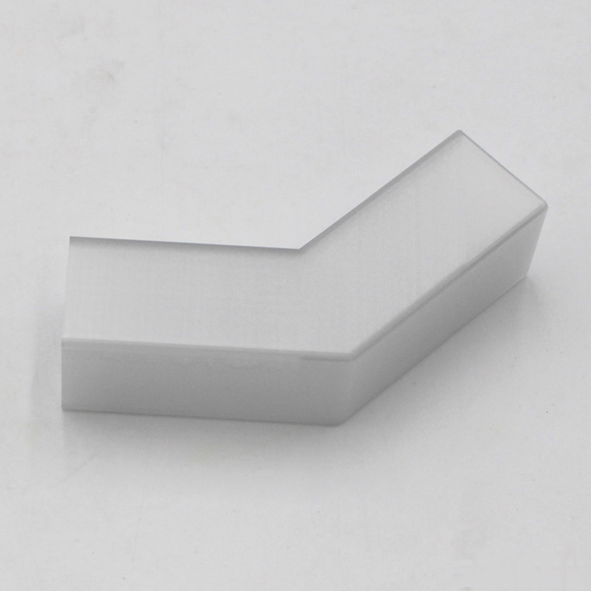 A translucent Elbow for Visby Profile with a beveled edge, possibly 3D printed, is placed on a light gray background.