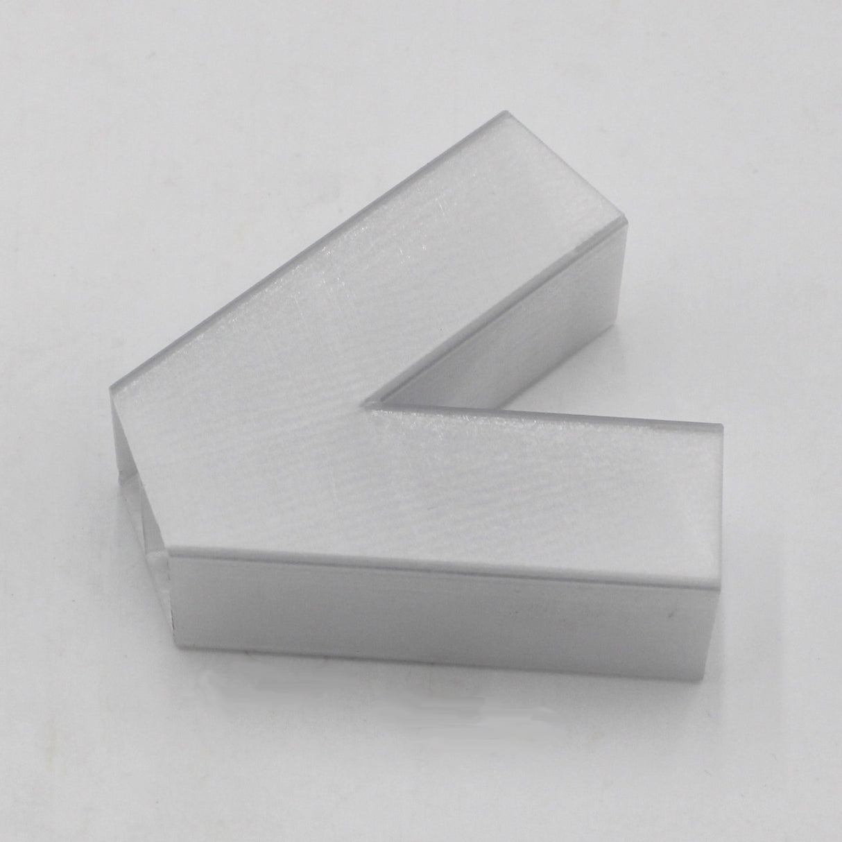 A translucent, three-dimensional elbow designed for the Visby Profile is positioned on a plain white background, its angled form suggesting motion to the left.