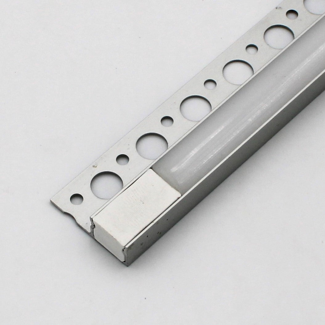 Close-up of the RGB LED Tile Edge Light Strip Kit (24V) ~ Nicho Series, featuring a white plastic edge and large circular holes, ideal for drywall or tile installation, shown on a light gray surface.