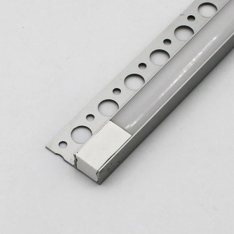 A close-up of the White LED Tile Edge Light Strip Kit (24V) ~ Nicho Series shows its aluminum channel with round mounting holes and a white plastic end cap, set against a plain white background.