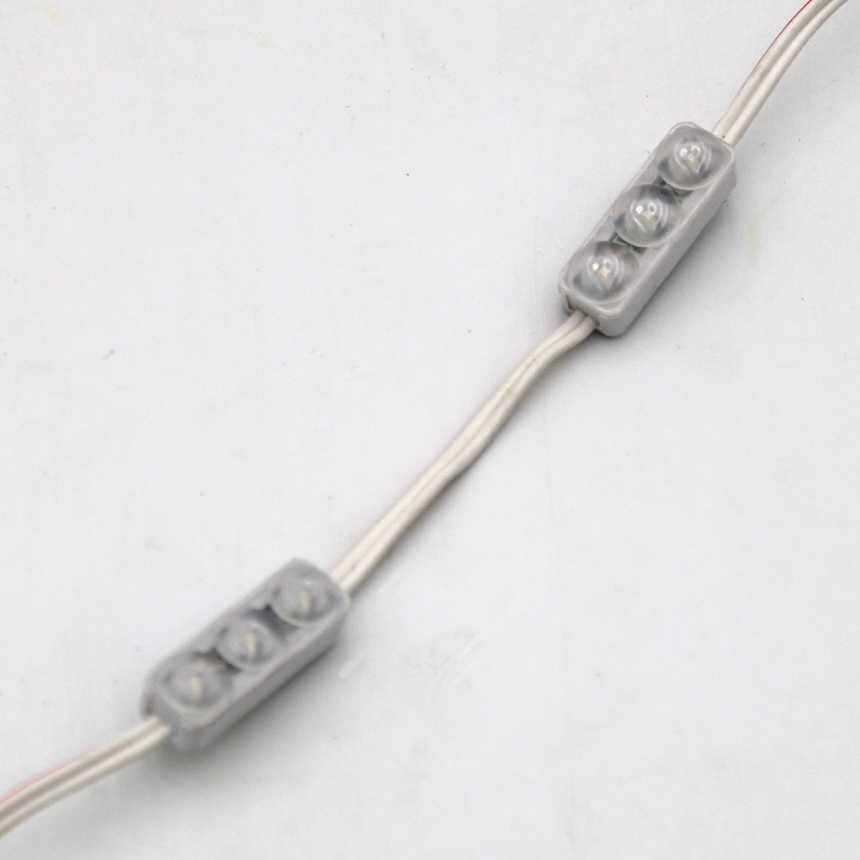 Close-up of two Mini3 Color 160 Mini LED Module ~ Wide Angle Series (IP68 waterproof) units, each with three small LED bulbs, connected by wires and placed on a plain white background.