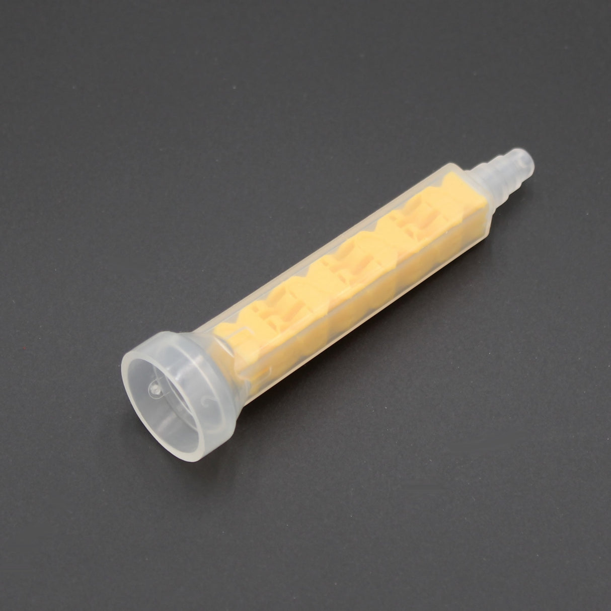 The High-Performance All-Ratio Mixer for 2-Part Methacrylate ~ Xemex C-System Threaded, featuring a transparent casing and yellow spiral insert, is shown against a dark background for dispensing and mixing adhesives.