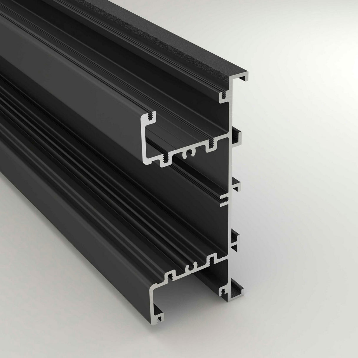 A close-up of the Up & Down Wall Feature Lighting LED Profile ~ Model New Washington, a black aluminum extrusion with multiple grooves, designed for LED accent installation in architectural projects, shown against a light gray background.