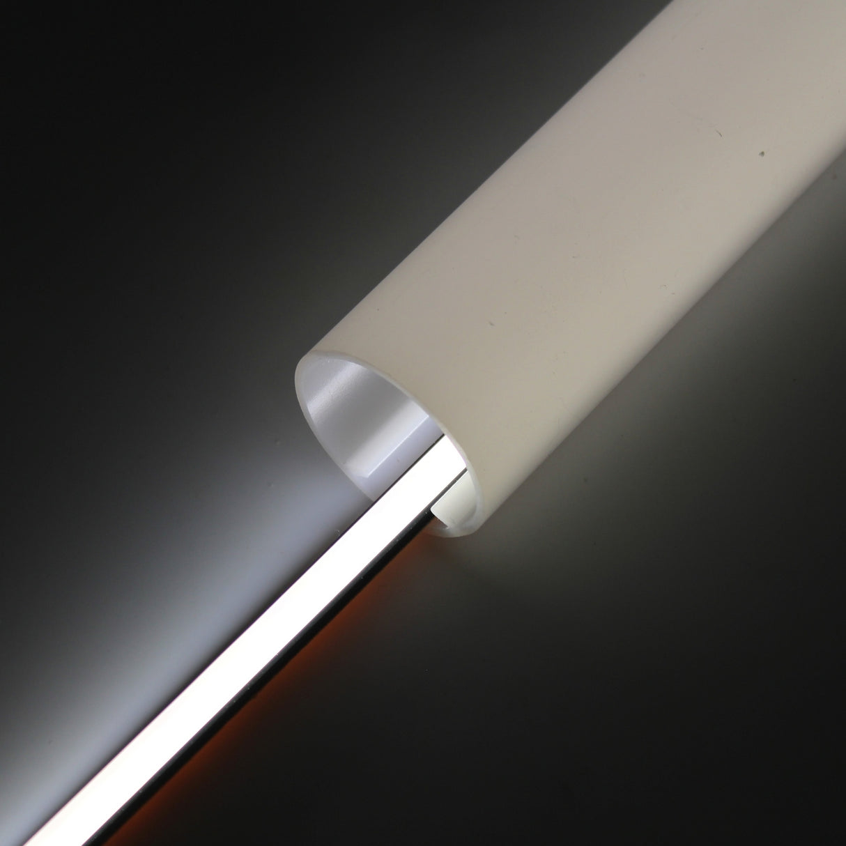 A close-up of the Optimum Black Neon Max Series: Black IP65 Neon LED Light Line (24V), featuring a glowing neon strip that casts dramatic light and shadow on a dark surface.
