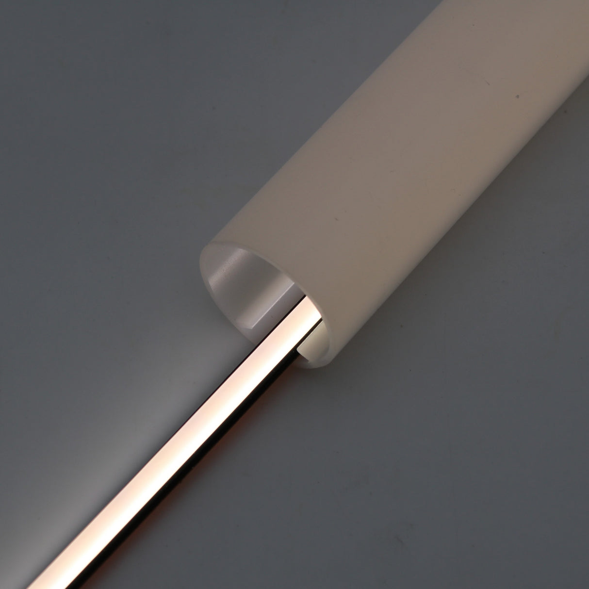 A close-up of the Black IP65 Neon LED Light Line (24V) from the Optimum Black Neon Max Series, featuring a glowing neon strip partially enclosed in a smooth, opaque casing against a neutral background.