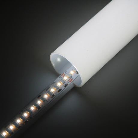 A close-up of the RGB+CCT IP20 LED Strip (24V) ~ Optimum Cromatic Series glowing inside a white cylindrical tube against a dark background, highlighting its tunable white lighting.