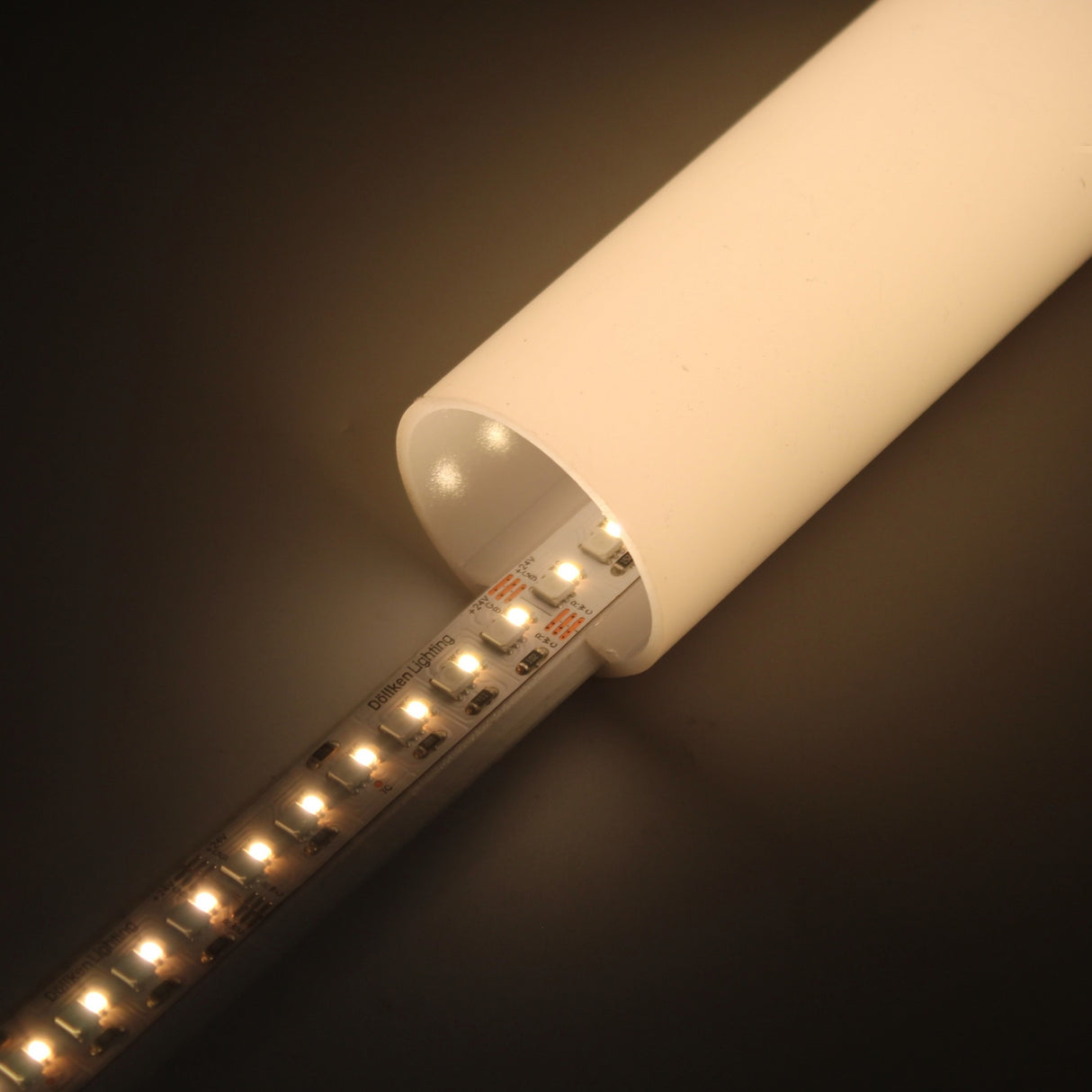The RGB+CCT IP20 LED Strip (24V) ~ Optimum Cromatic Series emits a warm, soft glow from inside a white tube and features tunable white lighting for improved energy efficiency.