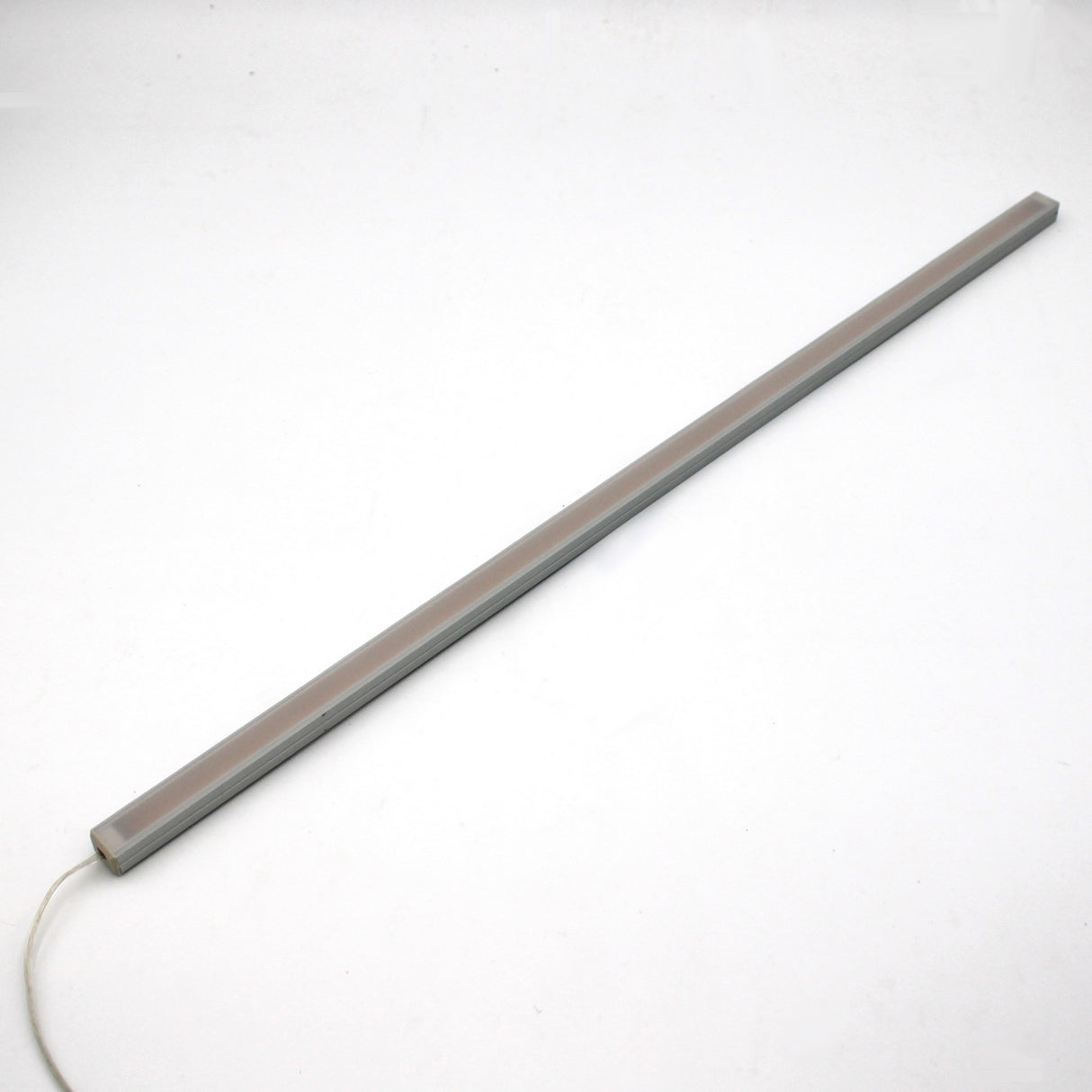 The White Universal Surface-mount Waterproof Outdoor LED Lighting Fixture (24V) from the Roma Series is a slim, rectangular, dotless bar with a white cord, shown diagonally on a white background—ideal for outdoor use.