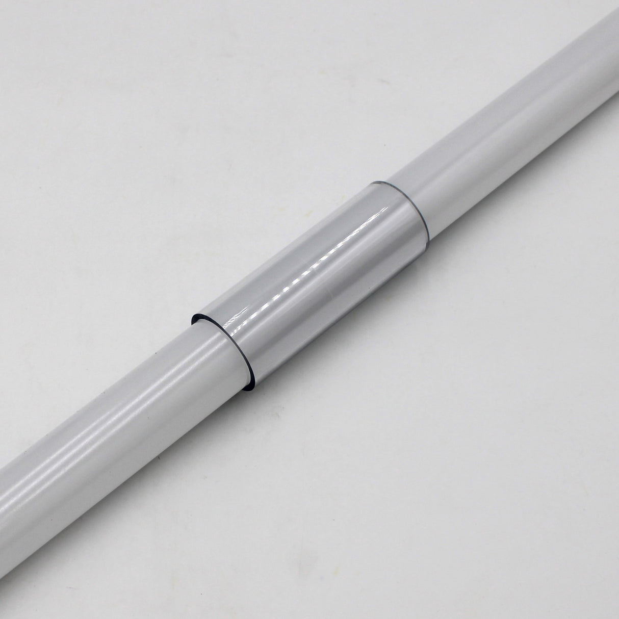 A close-up of the Clear Straight Joint for 1.50 Round Profiles connecting two white cylindrical rods, featuring black rings at the sleeve ends, set against a plain white background.