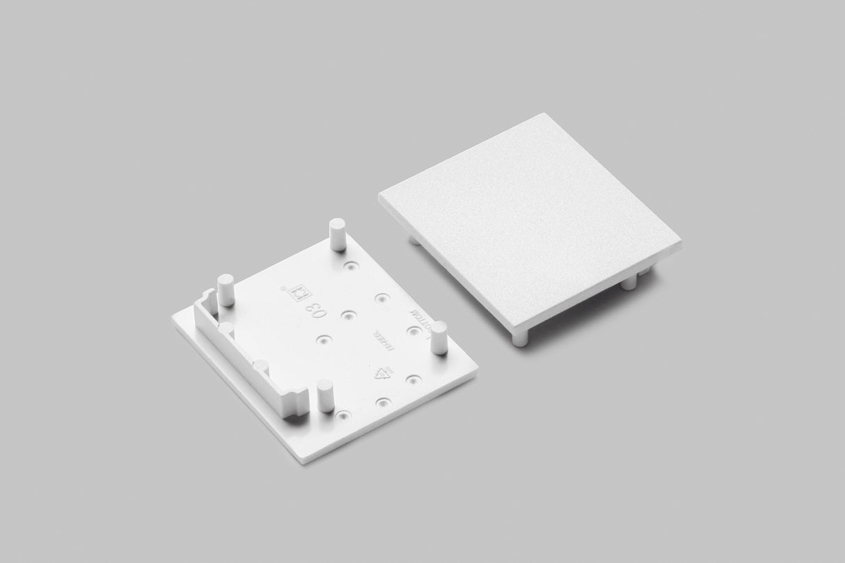 Two white, square plastic End Caps for Vario30-03 Profile are shown on a gray background. One reveals four pegs and small symbols; the other is flipped to display a smooth, flat side—ideal for your lighting fixture.