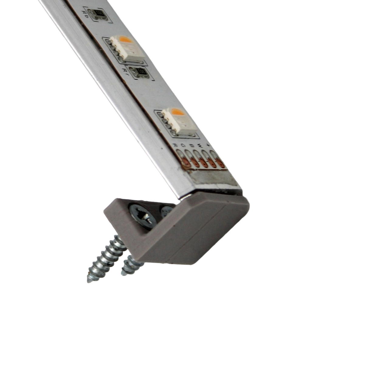 Close-up of a Surface Mount for Yukon Profile, showing an LED strip light attached with two screws. The strip is angled, displaying individual LEDs and wiring, along with related surface mount accessories.