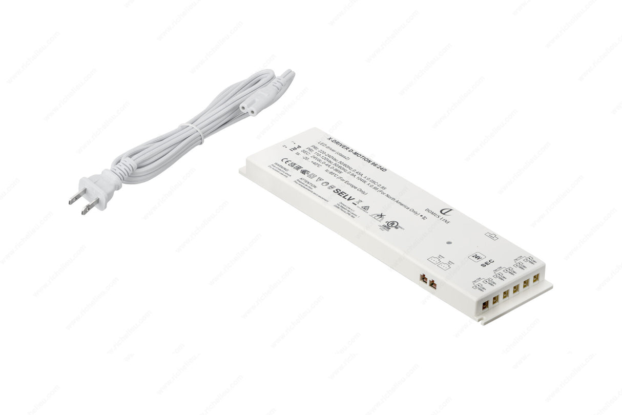 A white Dimmable Plug-In LED Driver (24V) from the X-Driver D-Motion Series with labeled terminals and a two-prong power cord, ideal for powering smart LED drivers or D-Motion luminaires, shown on a white background.