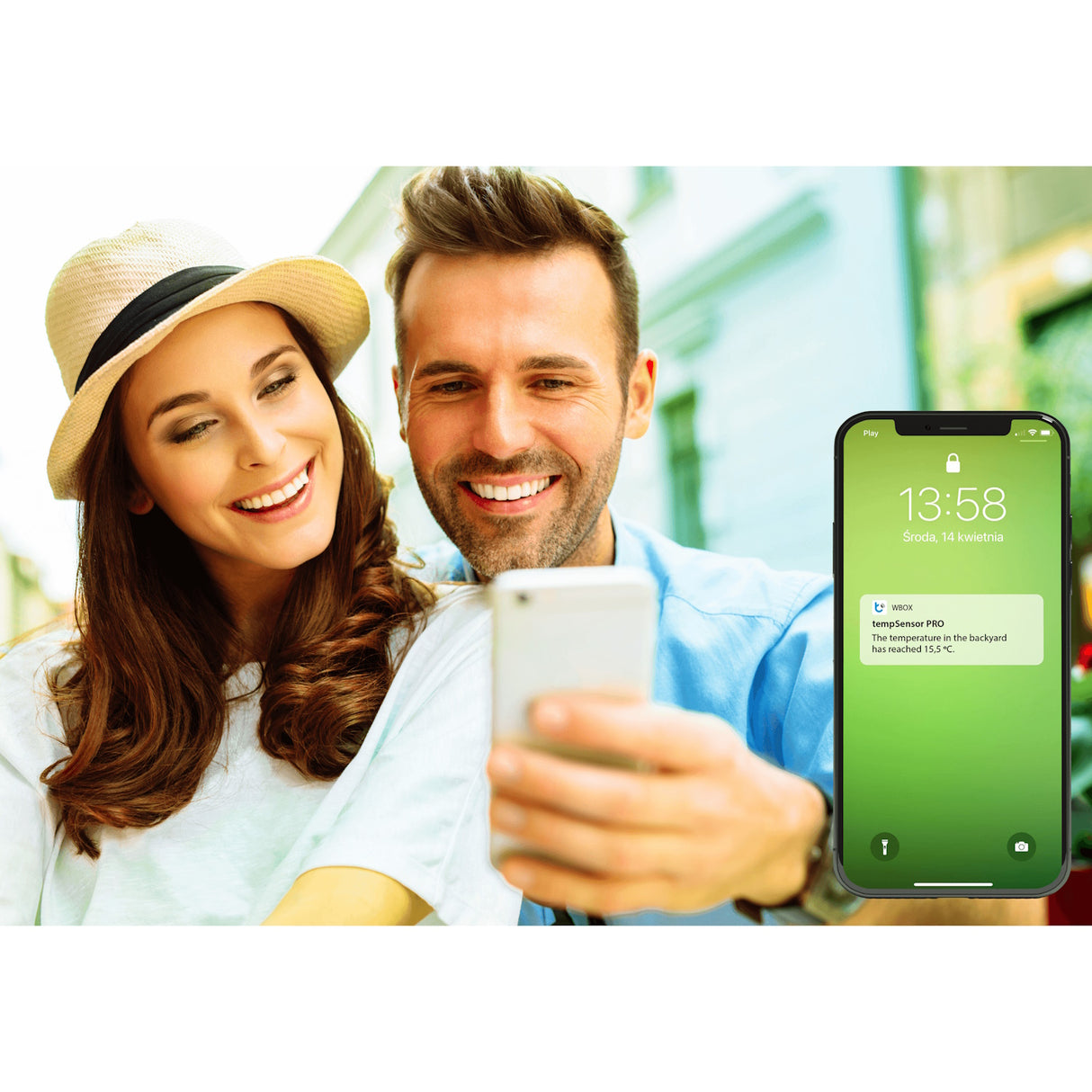 A smiling couple takes a selfie outdoors; beside them, a smartphone screen with a green background shows a notification from their Waterproof Smart Wireless Temperature Sensor ~ tempSensor Pro by Blebox.